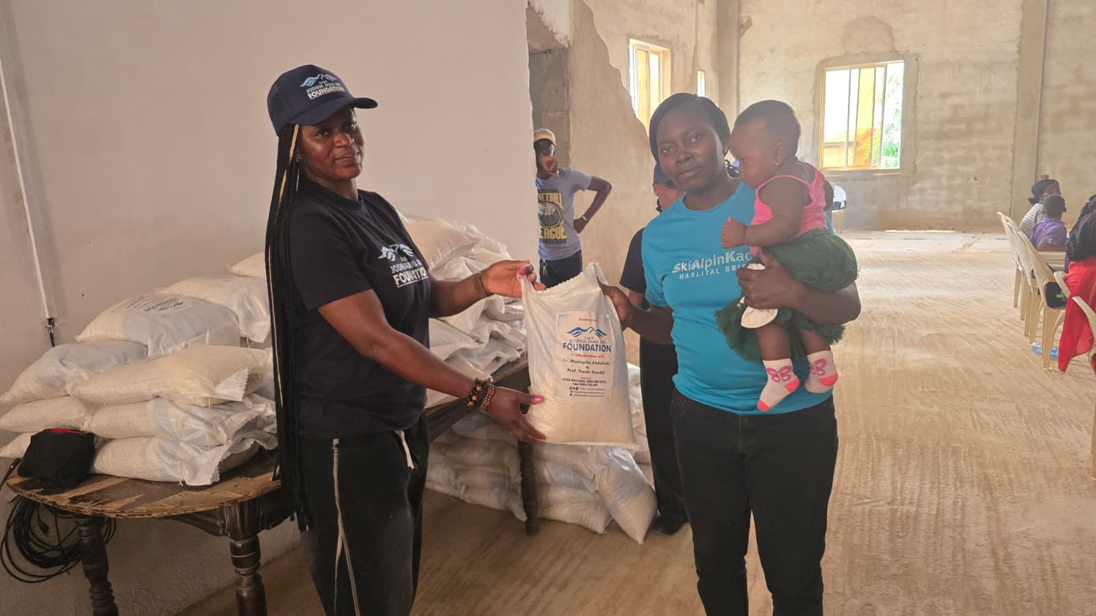 A mother receives a food relief bag during a widows support outreach